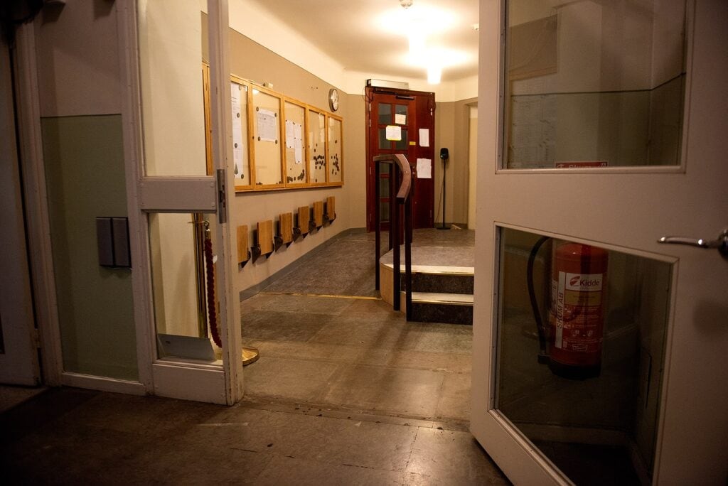 En korridor inne på Dramaten där korridoren delas av en ramp på en sida och två trappsteg bredvid rampen.