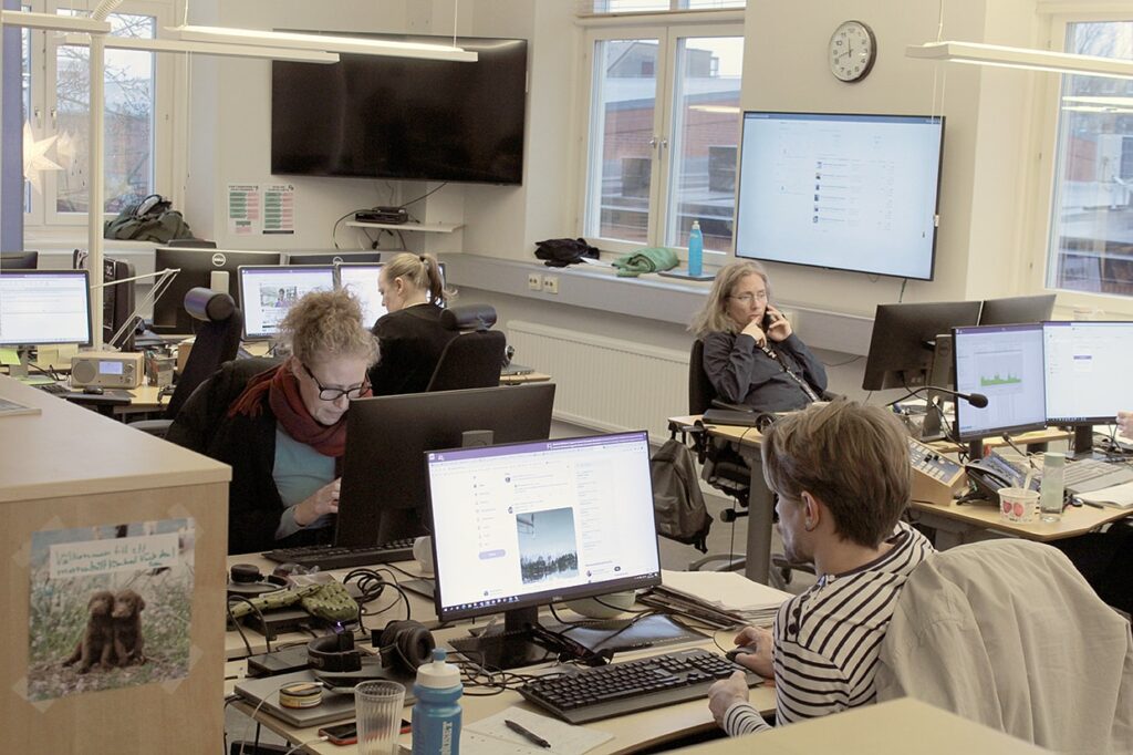 Medarbetare på Sveriges radio i Karlstad
Ett kontorslandskap med olika skrivbord och personer som sitter mitt emot varandra och arbetar.