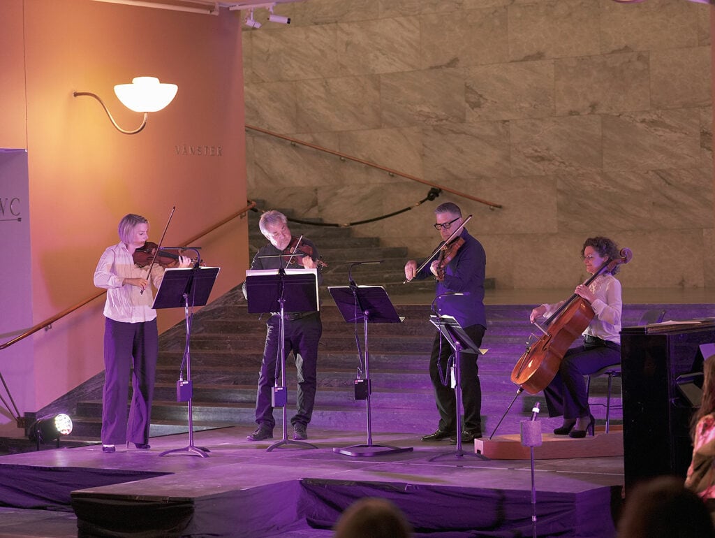 Scenbild på fyra personer med stråkinstrument med tre som står och spelar, varav Lars är en av dem, samt en sittande person som spelar cello.